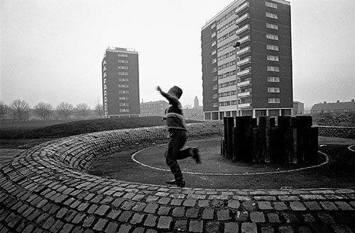 Boy playing by tower blocks, Birmingham  (1967)